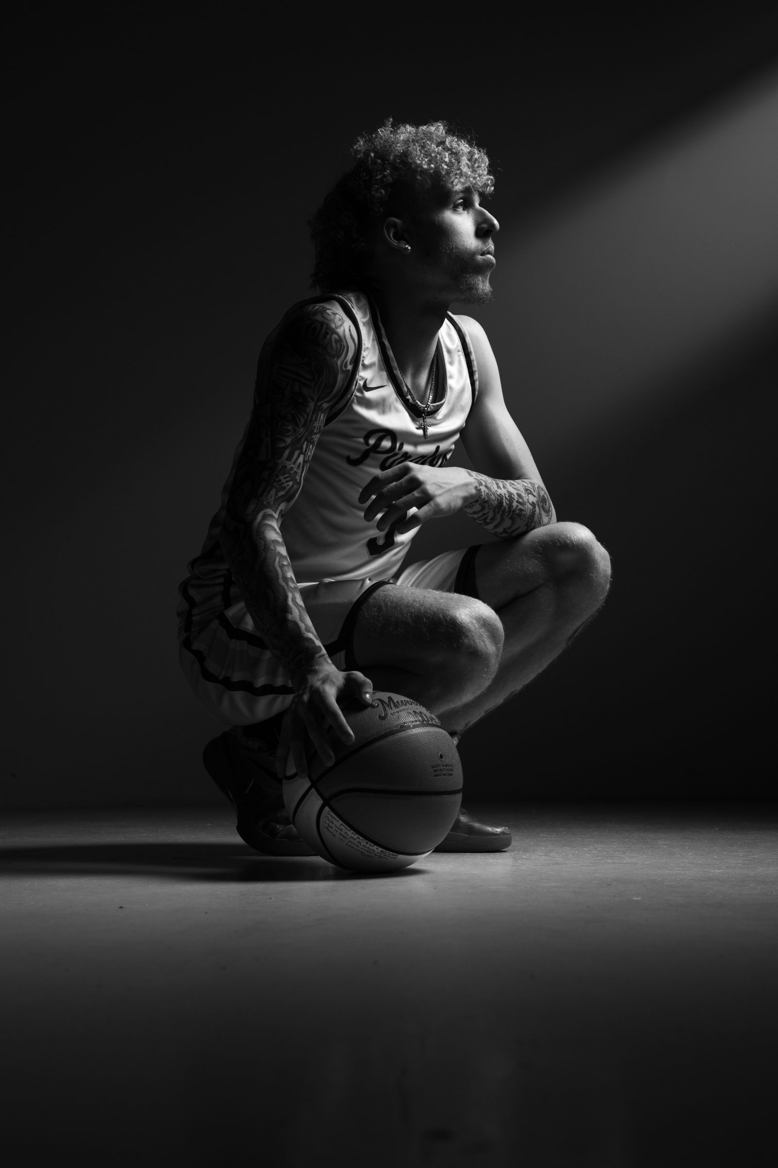 Black and white basketball senior lit by a single beam of light