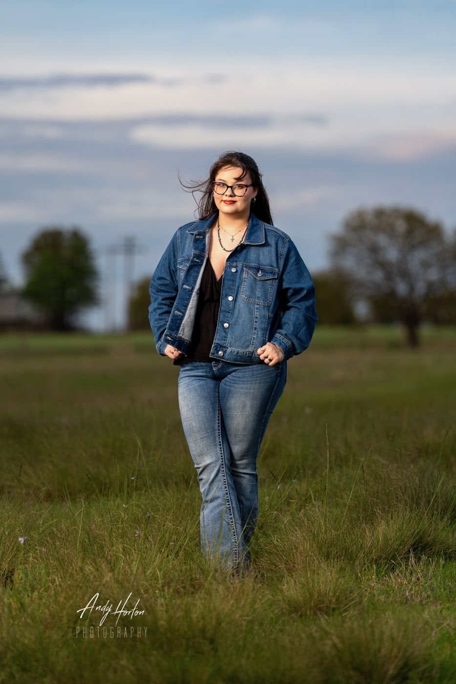 Senior in a denim jacket walking through a field